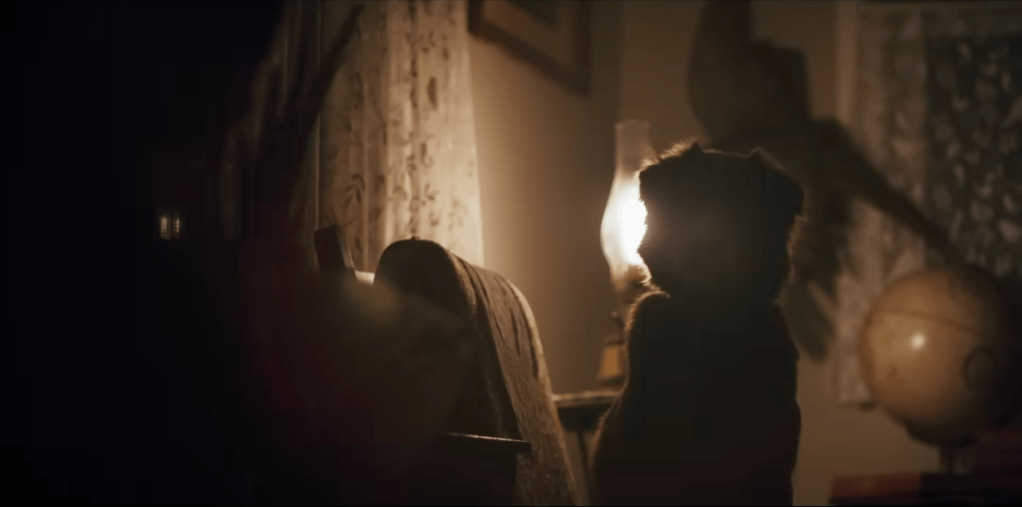 Indy sitting in a poorly lit room with shadows